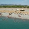 Spiaggia affollata con ombrelloni e bagnanti.