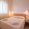 Camera da letto semplice con letto matrimoniale, comodini e luci soffuse.