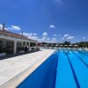 Piscina lunga con corsie, accanto a un edificio bianco e sdraio.