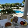 Tavolo con colazione davanti a una piscina.
