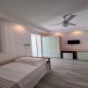 Camera semplice con letto singolo, armadio verde, TV e scrivania.