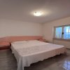 Camera da letto con pavimento piastrellato, letto matrimoniale e testiera rosa.