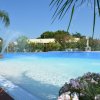 Piscina con fontane d'acqua e fiori colorati intorno.