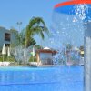 Fontana in una piscina con ombrelloni e palme sullo sfondo.
