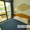 Camera da letto con letto matrimoniale e accesso al balcone.
