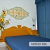 Camera con letto matrimoniale, copriletto blu e decorazioni floreali.