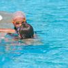 Bambini in piscina indossano occhialini.