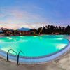 Piscina illuminata di sera con lettini blu.