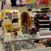 Una donna in un negozio di souvenir pieni di scaffali colorati.