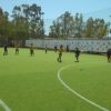 Bambini giocano a calcio su un campo con erba artificiale.
