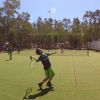 Ragazzo che gioca a tennis su un campo all'aperto.