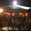 Locale affollato di notte con luci soffuse.