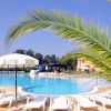 Piscina all'aperto con lettini e palme.