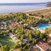 Vista aerea di un resort con piscina vicino al mare.