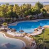 Grandi piscine all'aperto circondate da alberi e sdraio.