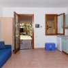 Soggiorno con divano blu e cucina verde chiara.