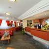 Bar di un hotel con arredamento rosso e uomo al bancone.