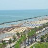 Spiaggia affollata con file di ombrelloni, vista sul mare.