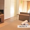 Camera con letto, TV su una scrivania, asciugamani e un armadio bianco.