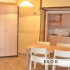 Cucina compatta con tavolo da pranzo, armadio e illuminazione pendente.