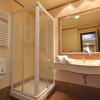 Un bagno con doccia, lavabo con specchio e asciugamani piegati.