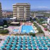 Piscina centrale circondata da ombrelloni e edifici moderni con vista dall'alto.