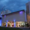Hotel illuminato di notte con palme.