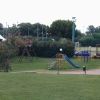 Parco giochi con altalene e scivolo.