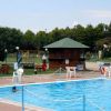 Piscina all'aperto con chiosco e parco giochi.
