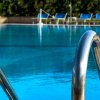 Piscina con sedie a sdraio in lontananza.
