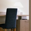 Scrivania con sedia e lampada accesa.
