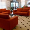 Sala d'attesa con divani arancioni.