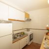 Cucina luminosa con elettrodomestici, frutta, e stoviglie.