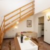 Soggiorno con tavolo apparecchiato, scala in legno e arredamento accogliente.