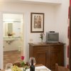 Una sala da pranzo con tavolo apparecchiato, credenza con TV e bagno sullo sfondo.
