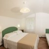 Una camera da letto con letto matrimoniale e letto singolo, lampada a soffitto e finestra.