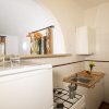 Cucina con fornelli, lavandino e ripiano, decorata con fiori e frutta.