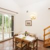 Sala da pranzo luminosa con tavolo apparecchiato, porte-finestre e scala in legno.