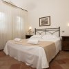 Camera con letto matrimoniale, lenzuola bianche e comodini in legno.
