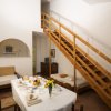 Sala con tavola imbandita e scale di legno che portano al soppalco.