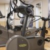 Interno di palestra con cyclette Technogym grigie.