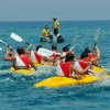 Persone in canoa che pagaiamo in mare.