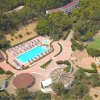 Veduta aerea di un complesso con piscina, campi sportivi e aree verdi.
