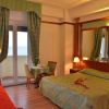 Una camera d'albergo con letto matrimoniale, divano rosso e vista mare.