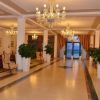 Un salone d'ingresso elegante con divani, poltrone, lampadari e piante.