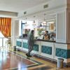 Un uomo al bar in un'elegante sala con tendaggi e sedie alte.
