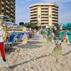 Spiaggia con sdraio e figure di cartone di personaggi.