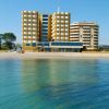 Edificio giallo e moderno che si affaccia sul mare.