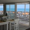 Ristorante con vista mare, tavoli bianchi.