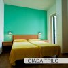 Stanza con due letti singoli, parete verde.